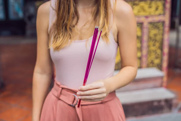 Incense sticks on joss stick pot are burning and smoke use for pay respect to the Buddha, Incense sticks in woman hands and smoke use for pray respect to the Buddha in Buddhism life.