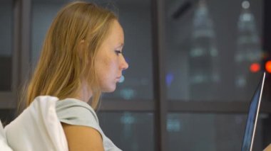 Genç kadın siluetleri ısıtmak bir amaç, ile onun yatağında oturmuş bir dizüstü bilgisayar kullanarak sohbet