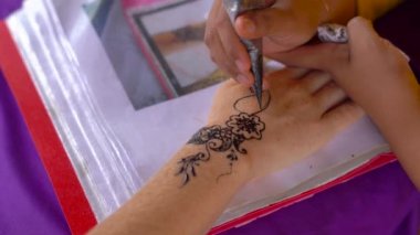 Genç kadın bir yandan bir hindu desen geçici bir kına anlıyor