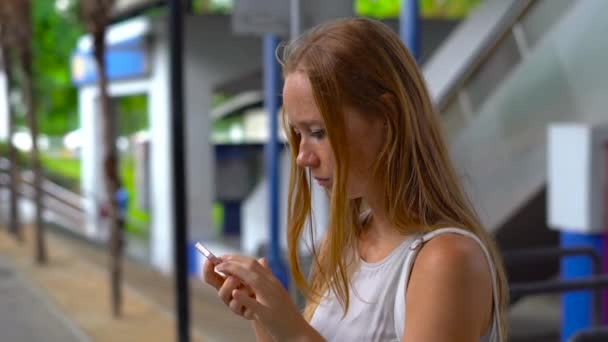 Młoda kobieta na ulicy stracił w wielkim mieście, starając się przeszukiwać mapy na jej telefon i zarezerwować taksówkę — Wideo stockowe