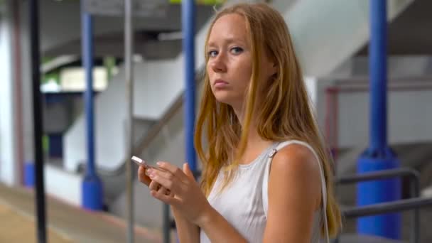 Jeune femme dans une rue perdue dans une grande ville, essayant de chercher à travers la carte sur son téléphone et réserver un taxi — Video