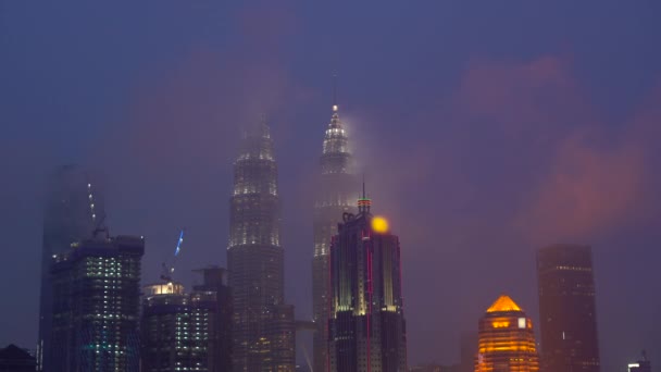 Paisagem urbana do centro da cidade de Kuala Lumpur com palhaços com nuvens flutuando passando pelas torres — Vídeo de Stock