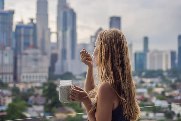 Молодая Женщина Ест Чиа Пудинг Балконе Видом Большой Город — стоковое фото