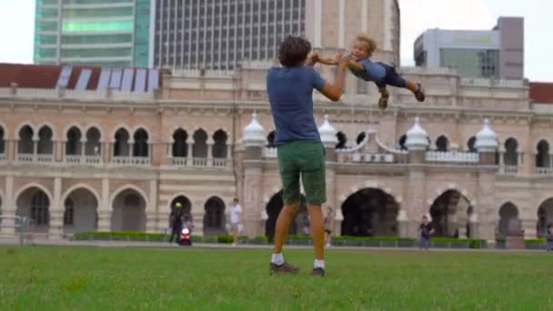 Far cirklande sin son på torget Merdeka, Kuala Lumpur, Malaysia — Stockvideo