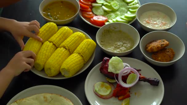 Draufsicht auf eine Familie, die ein indisches, malaiisches Essen isst — Stockvideo