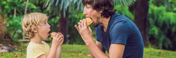 Retrato Joven Padre Hijo Disfrutando Una Hamburguesa Parque Sonriendo Banner —  Fotos de Stock