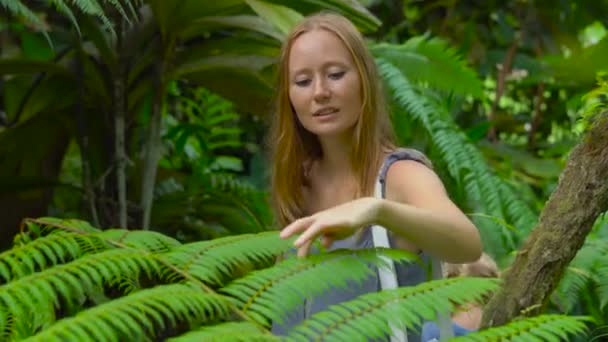 Mujer joven y su hijo visitando un jardín botánico tropical. sección de helecho — Vídeos de Stock