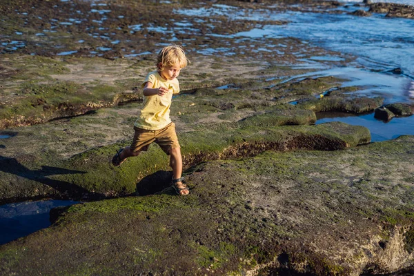 Çocuk kozmik Bali sahilde oynuyor. Portre seyahat turizm. Olumlu insan duyguları, aktif yaşam tarzları. Mutlu genç çocuk deniz plaj.