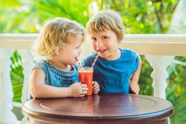 Erkek ve kız papaya meyve masada portakallı gazoz içme.
