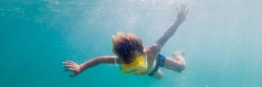 Denizde afiş, uzun biçimde sualtı dalış şnorkel maskesi giyen çocuk