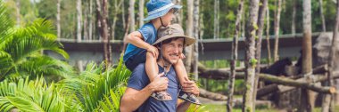 Baba ve oğul hayvanat bahçesinde. Bütün gün aile hayvanat afiş, uzun biçim ile