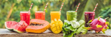 Smoothies gökkuşağı. Karpuz, papaya, mango, ıspanak ve dragon meyve. Smoothies, meyve suları, meyve suyu, içecekler, içecekler çeşitli taze meyve ile ahşap tablo.