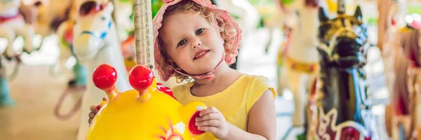 Linda niña disfrutando en la feria y montando en colorido carrusel casa BANNER, formato largo —  Fotos de Stock
