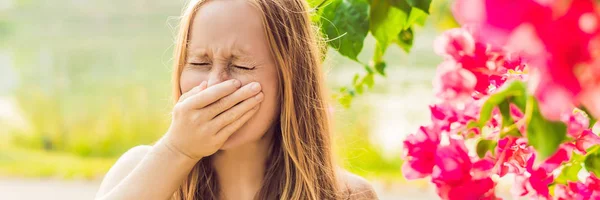 花粉アレルギーの概念 若い女性は くしゃみをする予定です バック グラウンドでの花木 バナー 長い形式 — ストック写真