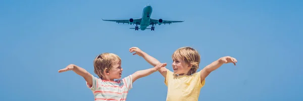 Due ragazzi felici sulla spiaggia e un aereo di atterraggio. Viaggiare con i bambini concetto BANNER, formato lungo — Foto Stock