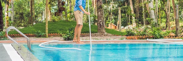 Male cleaner of swimming pool cleaning water from dirt