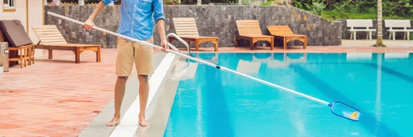 Male cleaner of swimming pool cleaning water from dirt