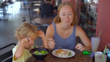 Genç kadın Asya yemekleri masada yemek ile küçük çocuk.