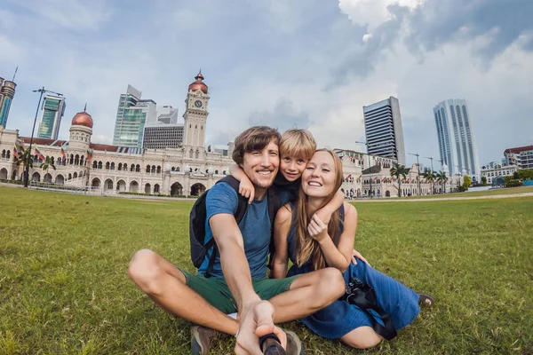 Šťastná rodina dělá selfie na pozadí na pozadí Merdeka square a Sultan Abdul Samad Building. Cestování s dětmi koncepcí — Stock fotografie