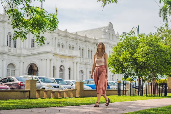 Young woman on the background of City Hall in George Town - Penang, Malaysia. British built historical building completed 1903 became the City Hall of George Town 1957.