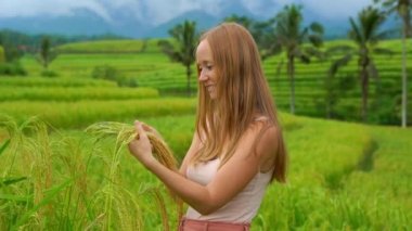 Yeşil alan ayakta ve yeşil buğday bitkiler elinde tutan genç güzellik Kızıl saçlı kadın