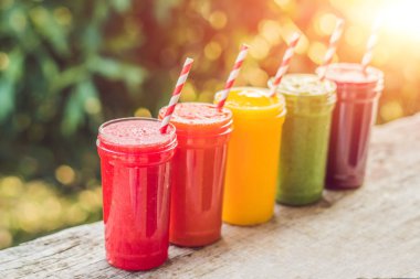 Smoothies gökkuşağı. Karpuz, papaya, mango, ıspanak ve dragon meyve. Smoothies, meyve suları, meyve suyu, içecekler, içecekler çeşitli taze meyve ile ahşap bir masaya.