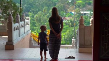 Genç bir kadın ve küçük oğlu Malezya 'nın Penang adasındaki Kek Lok Si Budist tapınağını ziyaret ediyor.