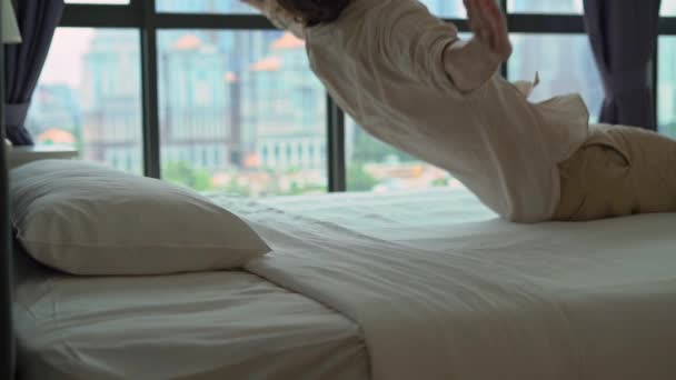 Superslowmotion plan d'un jeune homme tombant sur un lit — Video