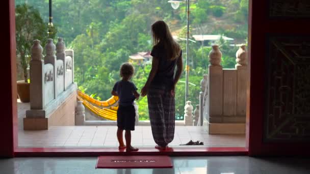 Eine junge Frau und ihr kleiner Sohn besuchen den buddhistischen Tempel Kek Lok Si auf der Insel Penang, Malaysia — Stockvideo
