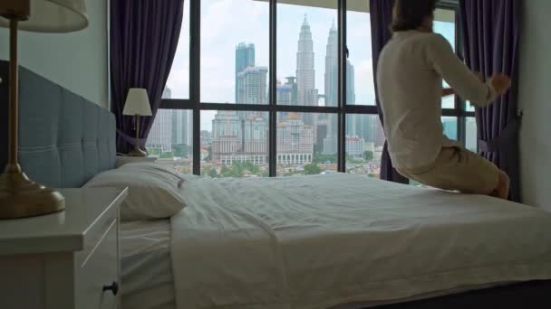 Fotografía en cámara lenta de un joven saltando a la cama. Concepto de colchón y almohada — Vídeos de Stock