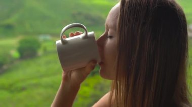 highlands çay plantattions manzaralı bir kafede oturan ve çay içme genç kadın.