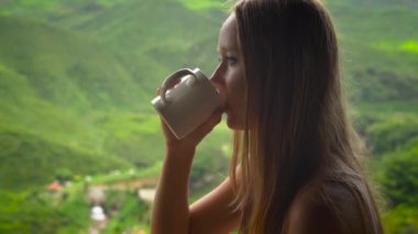 highlands çay plantattions manzaralı bir kafede oturan ve çay içme genç kadın.