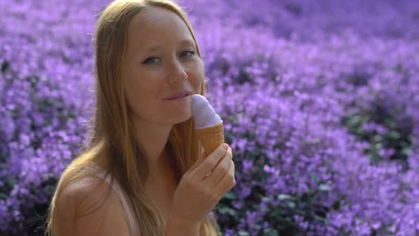 Jovem em uma fazenda de lavanda comendo um sorvete feito de lavanda — Vídeo de Stock