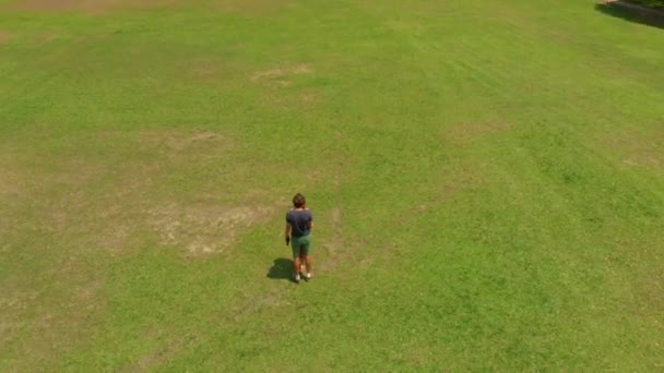 Tiro aéreo de um jovem casal beijando em um parque tropical — Vídeo de Stock