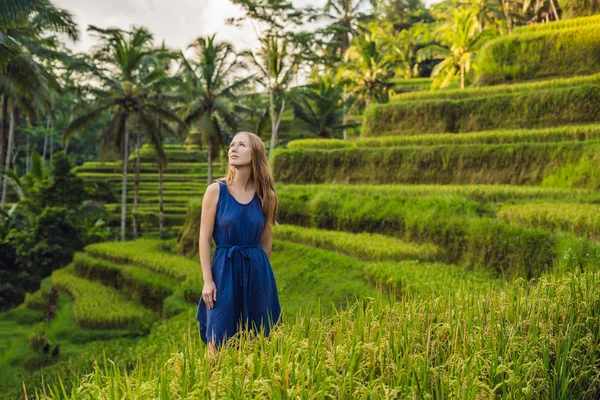 Young woman posing at Green cascade rice field plantation, Bali, Indonesia.