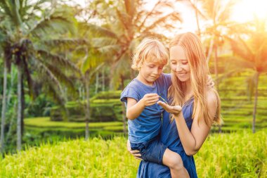 Anne ve oğlu yemyeşil yeşil poz pirinç terasları, Ubud, Bali, Endonezya.