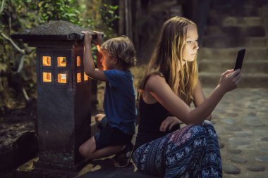 Anne oğlu parlak rahat evin penceresine bakarak onun smartphone arıyorum
