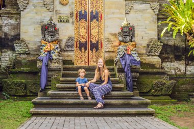 Anne ve oğlu turistlerin Bali Ubud Sarayı'nda merdivenlerde poz 