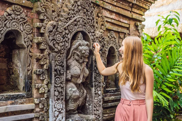 インドネシア バリ島 ウブド宮殿に切り分けられた壁の近くに立って若い女性旅行者 — ストック写真