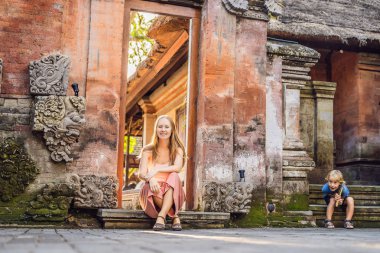 Bali Ubud sarayda oturan genç kadın ve çocuk yolcular 