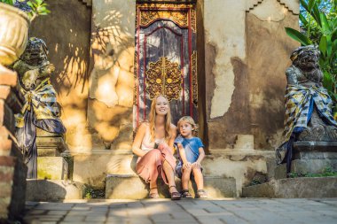 Merdiven Ubud sarayının, Bali, Endonezya oturan anne ve oğlu turist. 