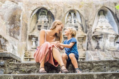 Anne ve oğlu Gunung Kawi poz. Antik tapınak kral mezarları ile taş oyma. Bali, Endonezya.