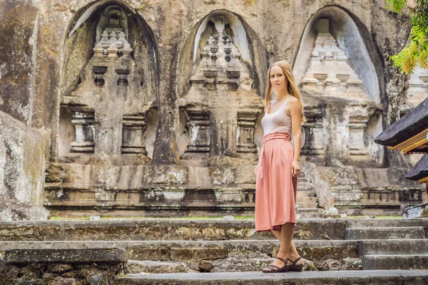 若い女性が近隣グヌン カウィ ポーズします 古代は 王家の墓の石の神殿に刻まれました インドネシア バリ島 — ストック写真