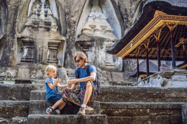 Baba ve oğul Gunung Kawi arka plan üzerinde. Antik tapınak kral mezarları ile taş oyma. Bali, Endonezya. Çocuk kavramı ile seyahat