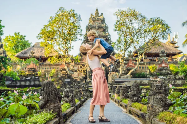 バリ島 バリ島 インドネシアのプラ タマン クムダ サラスワティ寺院に近いポーズのお母さんと息子の出張 — ストック写真