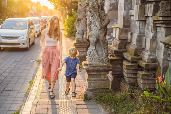 Mãe e filho viajantes estão andando ao longo da rua, Ubud Viajando com conceito de crianças . — Fotografia de Stock