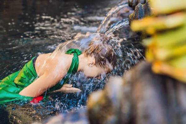 Genç kadın kutsal su bahar su akışı, Bali, Endonezya ile poz