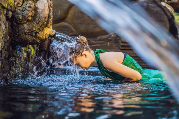 Genç kadın kutsal su bahar su akışı, Bali, Endonezya ile poz