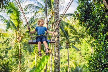Bali Adası, Endonezya avucunda ile ormanda salıncak üzerinde mutlu çocuk
