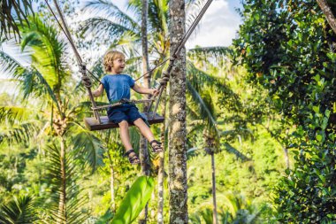 Bali Adası, Endonezya avucunda ile ormanda salıncak üzerinde mutlu çocuk